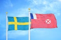 Sweden and Wallis and Futuna two flags on flagpoles and blue sky
