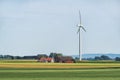 Swedish agriculture landscape with wind turbine in the field and wooden house Royalty Free Stock Photo