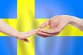 Swedish baby and parent hands on the background of flag of Sweden Help, aid, support, charity concept