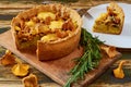 Swedish cheese and mushroom pie - quiche on the kitchen table decorated with rosemary. Sliced vegetarian chanterelles tart Royalty Free Stock Photo