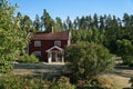 Swedish red and white traditional house in Smalland, White fence green garden blue sky