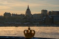 The swedish royal crown symbol, infront of Stockholm skyline in winter, with the old Church of Katarina in the background.