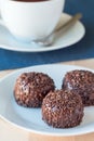 Swedish sweets Arrack balls, made from cookie crumbs, cocoa, butter and coconut wine Arrack flavour, on wooden table with a cup of