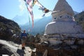 Swedish tourist next to white buddhist stupa on the Everest trek in Himalayas mountains, Nepal