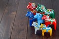 Swedish traditional souvenir wooden dala horses, hand craft made and painted, different colors and sizes, on wooden background,