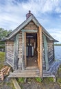 Swedish wooden sauna with open door, the woodstove is seen in interieur, the water of Gaxsjon lake is at background. Jamtland