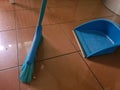 Sweeper and blue dustpan on tiled floor Royalty Free Stock Photo