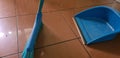 Sweeper and blue dustpan on tiled floor Royalty Free Stock Photo