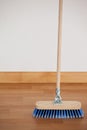 Sweeping broom with wooden handle on floor Royalty Free Stock Photo