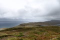 From Isle of Skye\'s iconic trail a moody landscape unfolds where land embraces misty Sound of Raasay