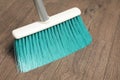 Sweeping wooden floor with plastic broom, closeup Royalty Free Stock Photo