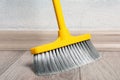 Sweeping wooden floor with plastic broom, closeup Royalty Free Stock Photo