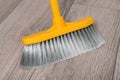 Sweeping wooden floor with plastic broom, closeup Royalty Free Stock Photo