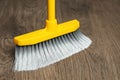 Sweeping wooden floor with plastic broom, closeup Royalty Free Stock Photo