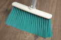 Sweeping wooden floor with plastic broom, closeup Royalty Free Stock Photo