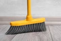 Sweeping wooden floor with plastic broom, closeup Royalty Free Stock Photo