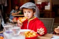 Sweet adorable child, boy, eating pizza at a restaurant Royalty Free Stock Photo