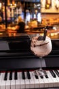 Sweet alcoholic chocolate cocktail garnished with biscuit on a piano in a night club