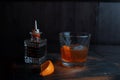 Sweet alcoholic syrup in a crystal goblet stands on a table in a pub next to a crystal bottle. The drink is decorated with orange Royalty Free Stock Photo