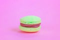 Sweet almond colorful unicorn yellow macaron or macaroon dessert cake isolated on trendy pink pastel background. French sweet
