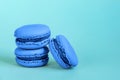 Sweet almond macaron or macaroon dessert cake colored in trendy color of year 2020 Classic Blue isolated on blue pastel background
