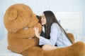 Asian girl sleeping on the bed with a big brown teddy bear. Royalty Free Stock Photo