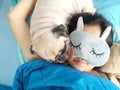 Sweet asian woman with mask and cute puppy pug dog is sleeping r Royalty Free Stock Photo