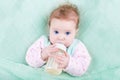 Sweet baby with big blue eyes drinking milk Royalty Free Stock Photo