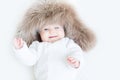 Sweet baby in a big fur hat Royalty Free Stock Photo