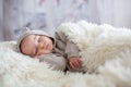 Sweet baby boy in bear overall, sleeping in bed with teddy bear Royalty Free Stock Photo