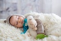 Sweet baby boy in bear overall, sleeping in bed with teddy bear Royalty Free Stock Photo