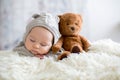Sweet baby boy in bear overall, sleeping in bed with teddy bear Royalty Free Stock Photo