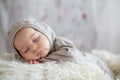 Sweet baby boy in bear overall, sleeping in bed with teddy bear Royalty Free Stock Photo