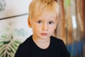 Sweet baby boy, closeup portrait of child isolated on wood background, cute toddler with blue eyes.