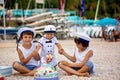 Sweet baby boy and his brothers, celebrating first birthday with sea theme cake and decoration Royalty Free Stock Photo
