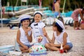 Sweet baby boy and his brothers, celebrating first birthday with sea theme cake and decoration Royalty Free Stock Photo