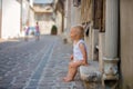 Sweet baby boy, sitting on the front porch of a house in an old part of the town, smiling happily Royalty Free Stock Photo