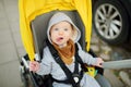 Sweet baby boy wearing warm clothes sitting in a stroller outdoors. Little child in pram. Infant kid in pushchair. Autumn walks Royalty Free Stock Photo