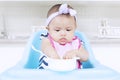 Sweet baby eating with bowl on chair Royalty Free Stock Photo