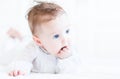 Sweet baby girl with beautiful blue eyes sucking on her fingers Royalty Free Stock Photo