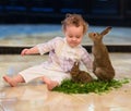 Sweet baby girl with curly hair with two rabbits Royalty Free Stock Photo