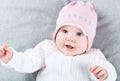 Sweet baby girl on a grey blanket wearing a pink hat Royalty Free Stock Photo