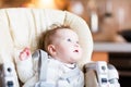 Sweet baby girl in a high chair waiting for dinner Royalty Free Stock Photo