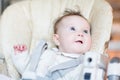 Sweet baby girl waiting for dinner in a high chair Royalty Free Stock Photo