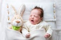 Sweet baby girl in a white crib with bunny toy Royalty Free Stock Photo