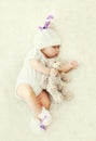 Sweet baby sleeping with teddy bear toy on white soft bed home Royalty Free Stock Photo