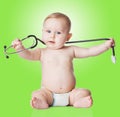 Sweet baby with stethoscope on a green background. Royalty Free Stock Photo