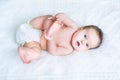 Sweet baby wearing a diaper playing with her feet Royalty Free Stock Photo