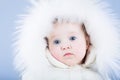 Sweet baby in a white snow suit with a fur hood looking tired Royalty Free Stock Photo