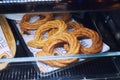 Sweet baked churros pretzel with cinnamon and caramel on counter in street cafe